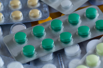 pile of multi-colored round tablets in blisters, background