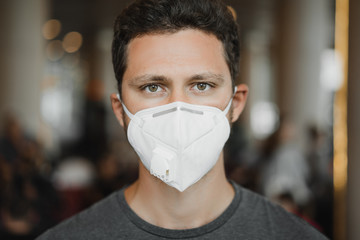 Close-up portrait of Men in respirator mask at the airport. Coronavirus COVID-19 and air pollution concept.