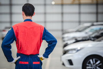 Asian mechanics wear their racing suits to turn back in repair shops and car repair centers. The...