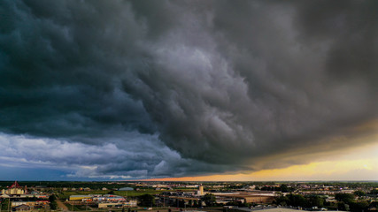 A large weather system rolls over small prairie city revealing magnificent colors in the sky.