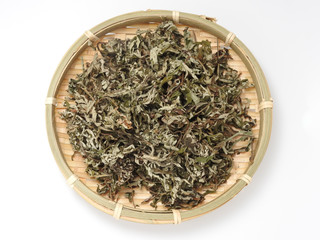 Top view of dry mugwort on bamboo plate isolated on white background.  Chinese medicine. During the Dragon Boat Festival, which is used to ward off evil spirits and to drive away mosquitoes.