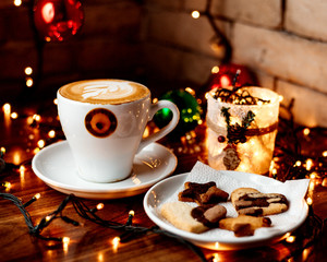 cup of hot cappuccino and a plate with cookies
