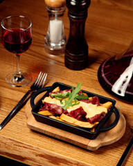 cured meat served with french fries and melted cheese