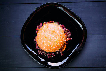 Fresh burger over wooden table and dark background. Top view