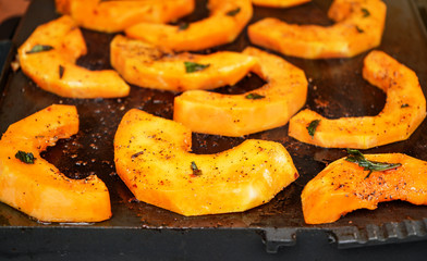 Bright orange butternut squash pieces with spices grilled on electric grill