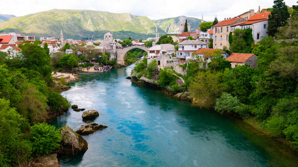 Fototapeta na wymiar Old town of Mostar and Stari Most bridge above beautiful emerald river Neretva. - April 2019, Mostar, Bosnia and Herzegovina.