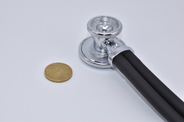 Stethoscope and 50 cents, euro coin on white background as a concept of healthcare costs is expensive.