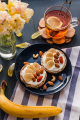 spring breakfast. cup of tea with lemon and banana and almond toast. breakfast at home. breakfast idea. simple breakfast decoration