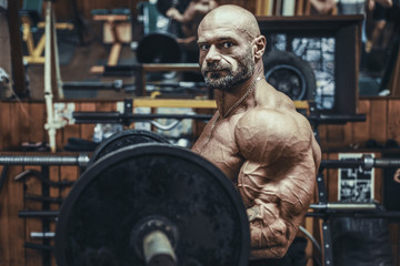 Obraz na płótnie Canvas Bodybuilder strong man pumping up biceps muscles.