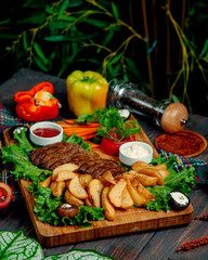 fried meat and potatoes at home on a wooden board