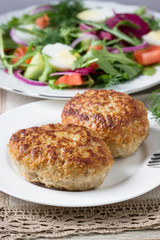 Fried cutlets and  salad made from fresh herbs.