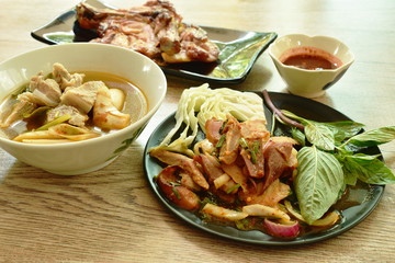 spicy roasted pork Thai salad and pork bone soup with grilled chicken dipping sauce on table