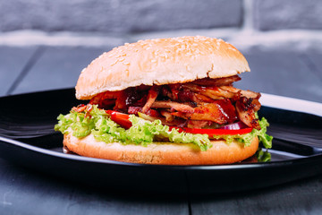 Fresh burger over wooden table and dark background. Front view