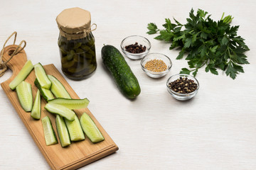 Canned cucumbers, chopped cucumbers on cutting board, green parsley, garlic and spices.