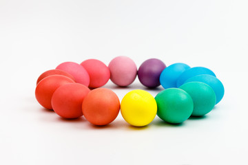 Easter multicolor eggs isolated on a white background. Rainbow. Copy space. Flat lay. Side view.