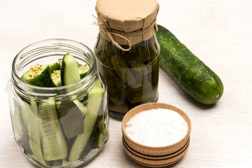 Chopped cucumbers in glass jar, salt. Canned cucumbers,