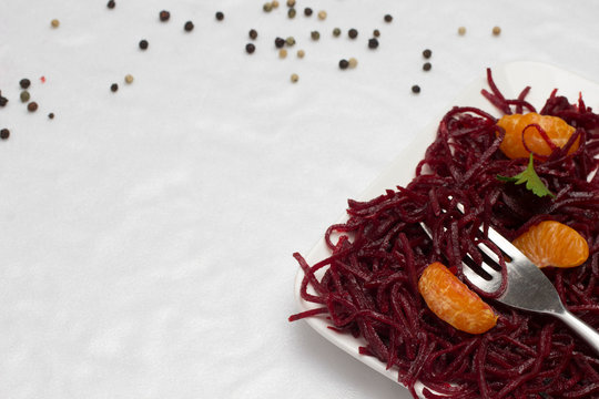 Two Slices Of Tangerine On Sliced Fermented Beets And Fork In Plate.