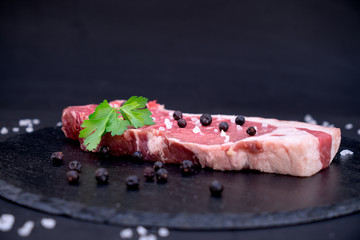 raw meat on a plate with salt and juniper berries