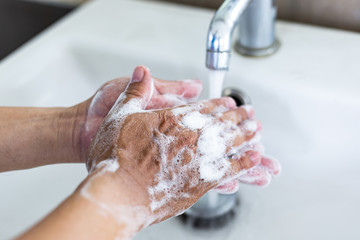 Man is washing his hands in a sink sanitizing the colona virus for sanitation and reducing the spread of COVID-19 spreading throughout the world, Hygiene ,Sanitation concept.