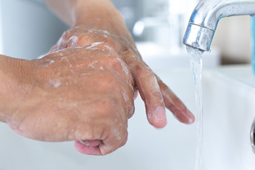 Fototapeta premium Man is washing his hands in a sink sanitizing the colona virus for sanitation and reducing the spread of COVID-19 spreading throughout the world, Hygiene ,Sanitation concept.
