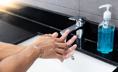 Man is washing his hands in a sink sanitizing the colona virus for sanitation and reducing the spread of COVID-19 spreading throughout the world, Hygiene ,Sanitation concept.