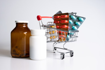 Medicine, vitamins and antioxidant supplements in trolley or shopping cart on white background