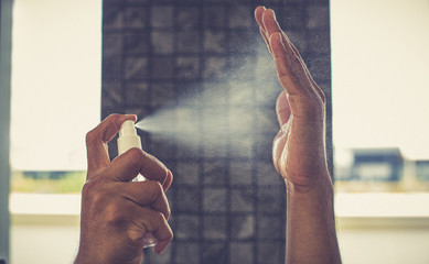 Man uses a spray of alcohol to get rid of bacteria and viruses, Inhibition and prevention of...