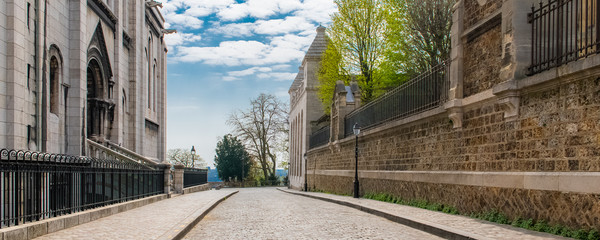 Paris, Montmartre, typical paved street, with the Sacre-Coeur basilica on the left


