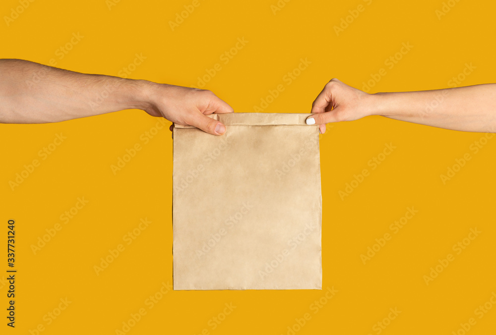 Poster takeaway food. delivery man giving paper bag with empty space for design to client, orange backgroun