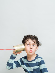 Little boy holding a can with a cord
