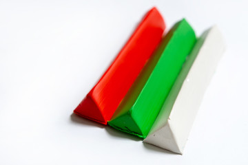 Fototapeta premium Three multi-colored plasticine bars on a white background. material for children's creativity. isolate.