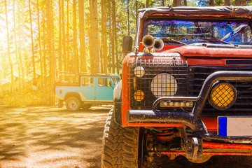 Old dirty jeep for tourist trips in a pine forest, close-up. Summer. The concept is outdoor...