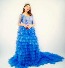 Beautiful young woman in gorgeous blue long dress like Cinderella with perfect make-up and hair...