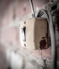 Old light switch on a brick wall .