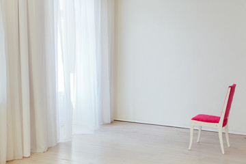 one red chair in the interior of an empty white office