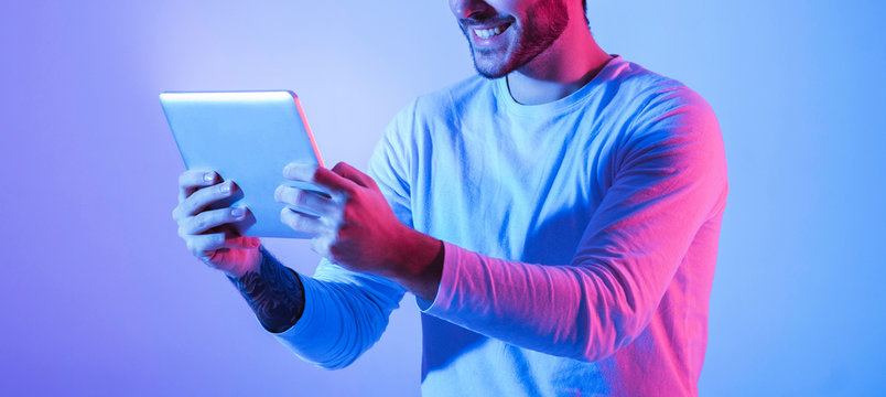 Man in neon with tablet in hands
