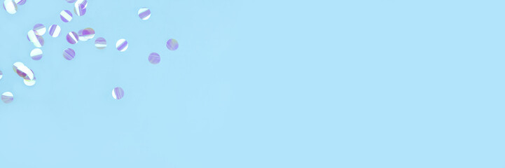 Pearl confetti on blue background. Flat lay, top view.
