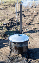 Large wrought iron cauldron on a metal furnace .