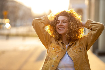 Portrait of young woman with curly hair in the city
