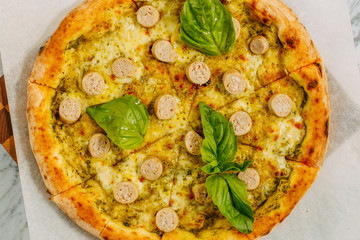 Italian pizza with mozzarella cheese and basil on a marble table