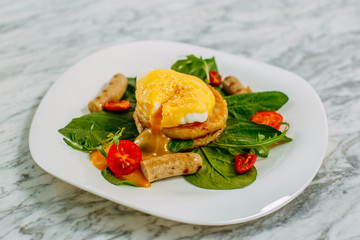 fritters with boiled egg and chicken sausages on a marble table