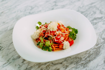 Italian spaghetti with cheese and herbs on a marble table