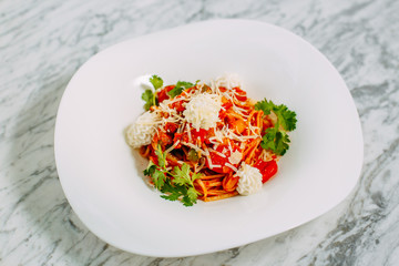 Italian spaghetti with cheese and herbs on a marble table