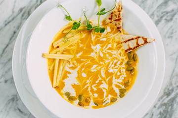pumpkin soup with crackers on a marble table