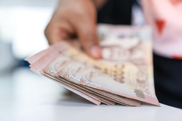 Weak baht, Thai baht banknotes, Businessman's hands counting money. one thousand baht. (THB) is...