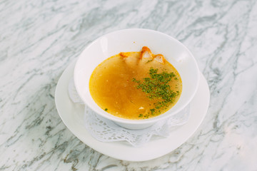 homemade noodle soup with chicken on a marble table