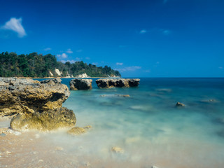 Turquoise water under a clear sky at the rocky Sitapur beach in the Andamans, India