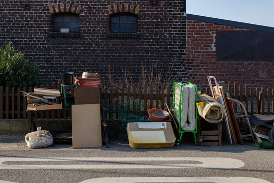 Unwanted Furniture And Household Stuffs Outside The Brick House On The Street Of Countryside In Germany. Used Furniture Wait For Picked Up Because Moving Out The House.