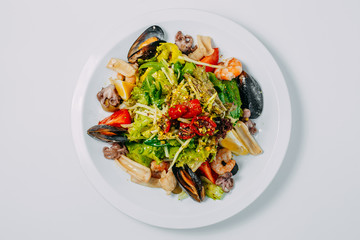 salad with seafood and vegetables, with mussels, octopus, squid and shrimp isolated on a white background