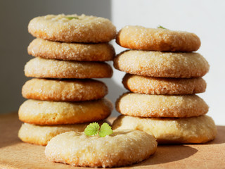 Sugar cookies on a wooden background. Two piles of fresh cookies.